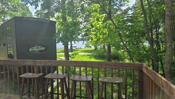 A wooden deck with a view of a lake and trees.