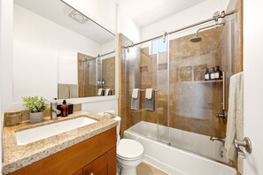 Une salle de bain moderne avec une douche à parois de verre, un lavabo blanc et un meuble-lavabo en bois.