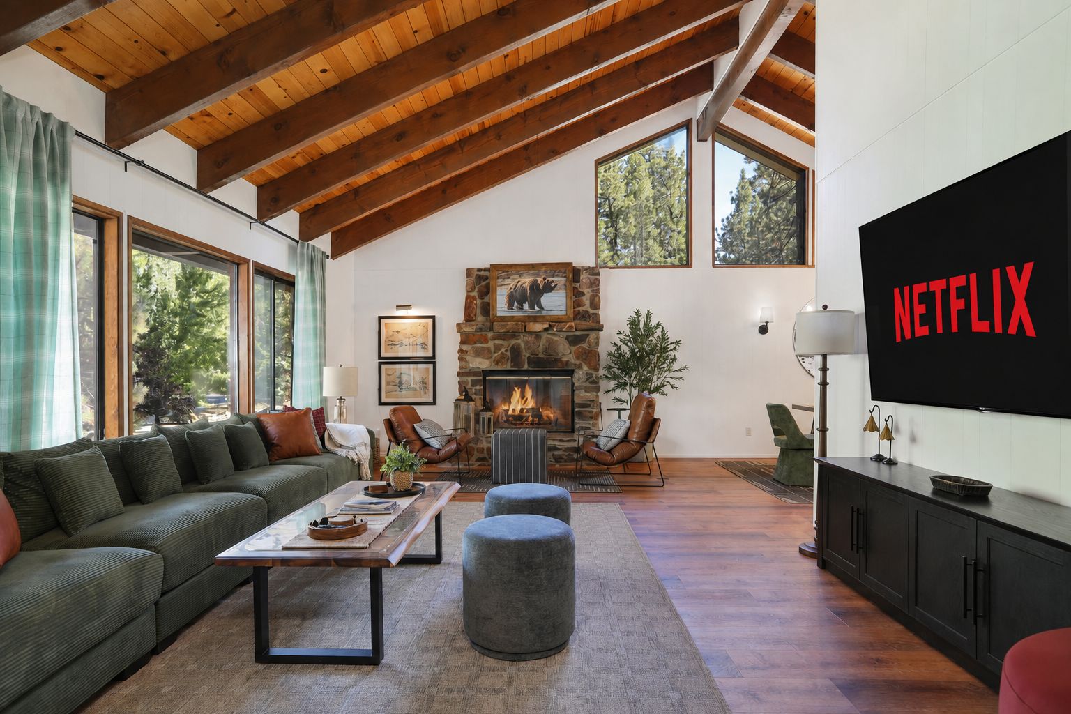 A spacious living room with a stone fireplace, a large TV screen, and a cozy seating area.