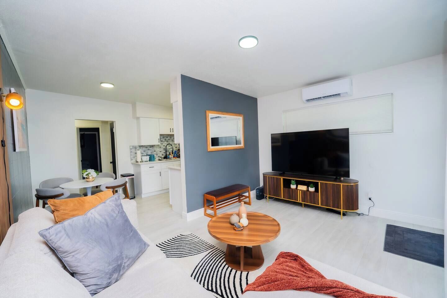 A modern living room with a sofa, coffee table, and a flat-screen TV.