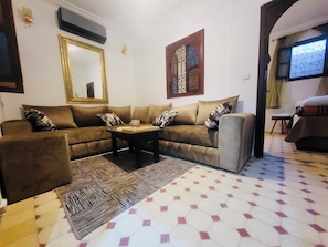 A living room with a sofa set, a coffee table, and a patterned rug. - We Host 212 l Every Stay in Marrakech Worth Repeating (Marrakesh)