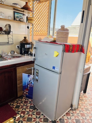A kitchen with a refrigerator, a coffee maker, and various kitchenware. - We Host 212 l Every Stay in Marrakech Worth Repeating (Marrakesh)
