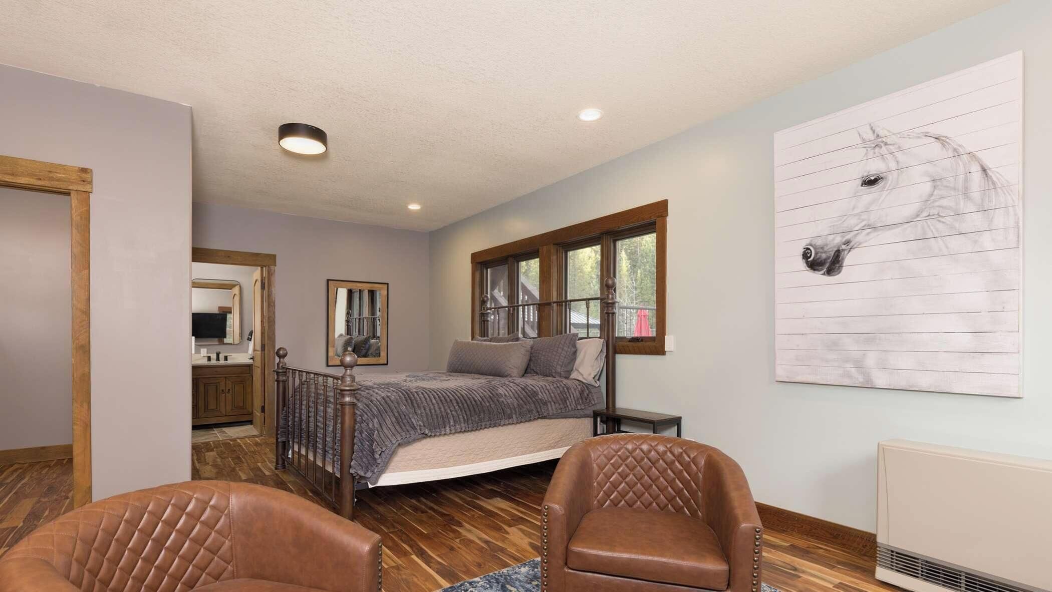 A bedroom with a bed, a window, a horse painting, and a chair.