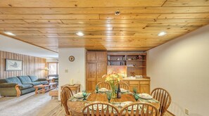 Un comedor con una mesa de madera dispuesta para cuatro personas, rodeada de sillas.