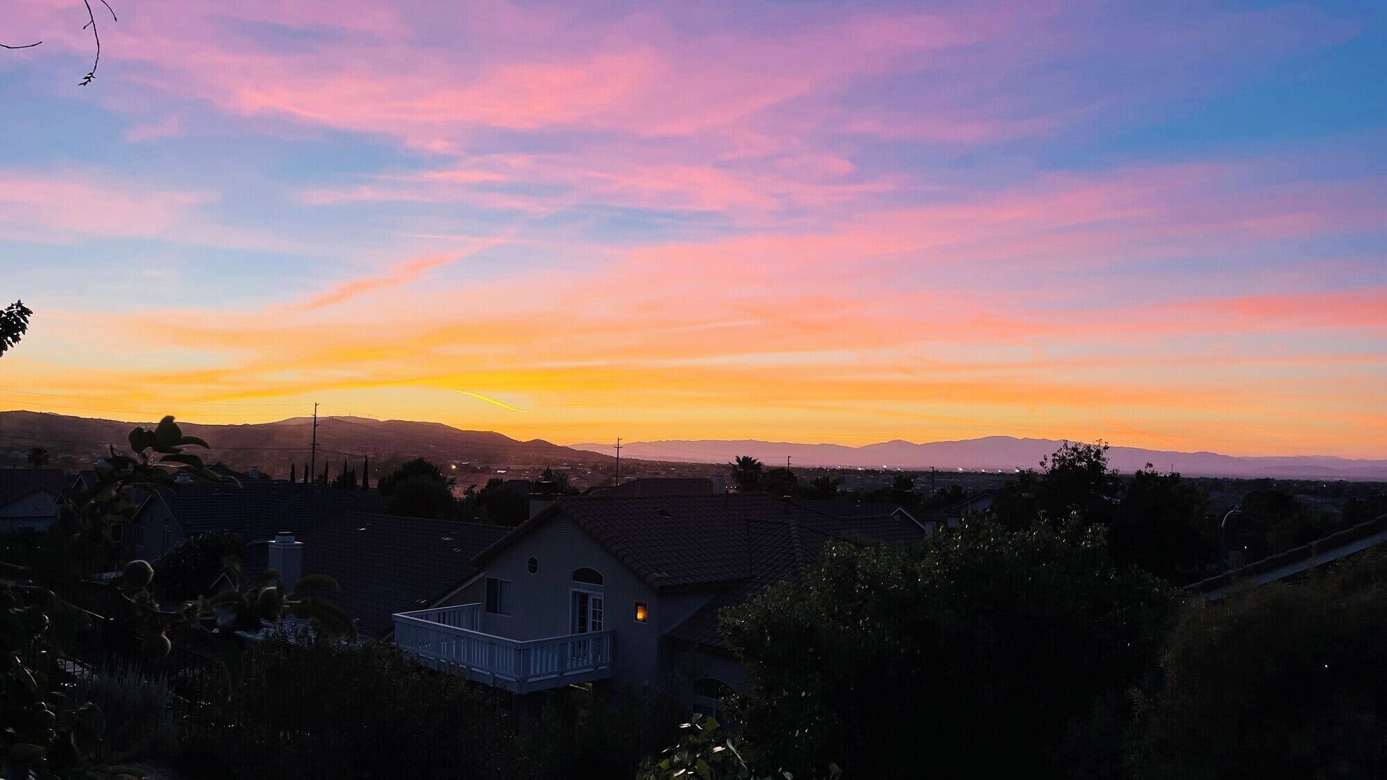 Un quartier résidentiel avec des maisons, au coucher du soleil.