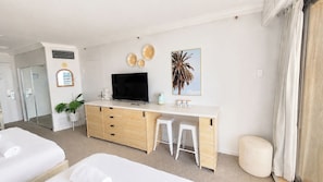 A hotel room with a bed, a desk with a TV, a mirror, and a plant. - Stylish Hotel Room | near Beach and Tram | Max 4 (Surfers Paradise)