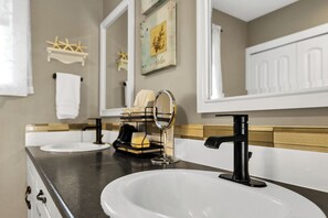 Une salle de bain avec deux lavabos, un miroir et un porte-serviettes.