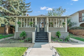 A two-story house with a front porch, a staircase, and a mailbox.