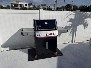 A black outdoor grill with a digital display, a side burner, and a red ignition knob. - Sandy Smiles - Gulf View 1-Min-Beach - Heated Pool (Fort Myers Beach)