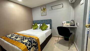 Una habitación de hotel con una cama, un escritorio y una silla.