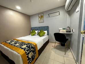 Una camera d'albergo con un letto, una scrivania e una sedia.