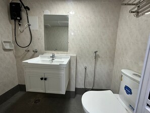 Un bagno con lavandino, specchio e WC bianchi.