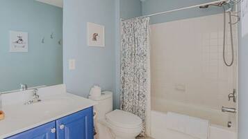 A bathroom with a bathtub, toilet, and sink.