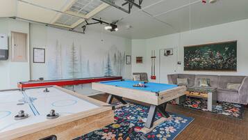 Une salle de loisirs équipée d’une table de billard, d’un baby-foot et d’une table de ping-pong.