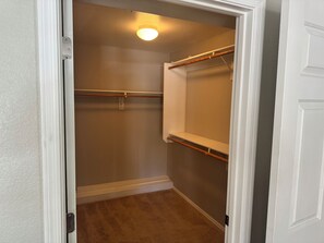 A walk-in closet with a wooden rod, a white shelf, and a carpeted floor. - Cozy 2-bedroom condo in marvelous Fountain Hills, Arizona (Fountain Hills)
