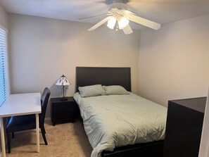 A bedroom with a bed, a desk, a chair, a nightstand, and a ceiling fan. - Cozy 2-bedroom condo in marvelous Fountain Hills, Arizona (Fountain Hills)