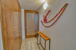 Ein Flur mit einem Holzkleiderschrank, einer Schiebetür und einem Holzkonsolentisch.