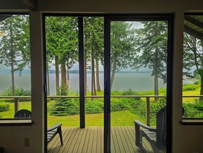 Eine Terrasse mit Blick auf einen See und Bäume.