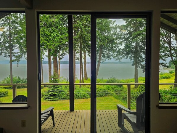 Una terraza con vistas a un lago y árboles.