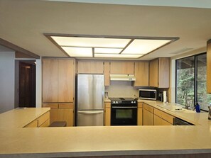 Una cocina moderna con electrodomésticos integrados, un ventanal y vistas al exterior.