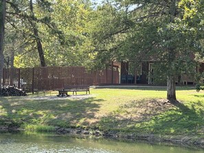 A park with a pond, benches, and a wooden fence. - Cozy Pondside Cabin Near Lake Ouachita (Mount Ida)