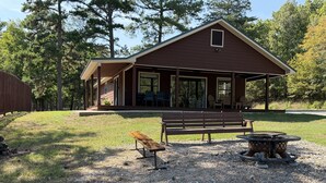 A cabin with a porch, a bench, and a fire pit. - Cozy Pondside Cabin Near Lake Ouachita (Mount Ida)