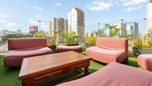A rooftop terrace with a seating area featuring a wooden table and two sofas. - Diez Canseco 2W Apartments Service (Miraflores)