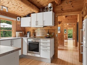 A modern kitchen with wooden beams, white cabinets, and a built-in oven. - "Greta" - 1.7km from the sea by Interhome (Rørvig)