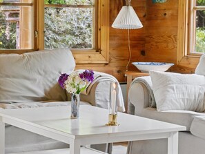 A cozy room with a white sofa, a white table, and a vase with flowers. - "Greta" - 1.7km from the sea by Interhome (Rørvig)