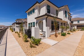 A two-story residential building with a patio area, a small garden, and a clear sky. - Desert Oasis - Pool, Hot Tub and Pickleball Courts (Washington)
