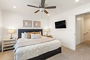 A bedroom with a bed, two nightstands, a ceiling fan, a flat-screen TV, and artwork on the wall. - Desert Oasis - Pool, Hot Tub and Pickleball Courts (Washington)