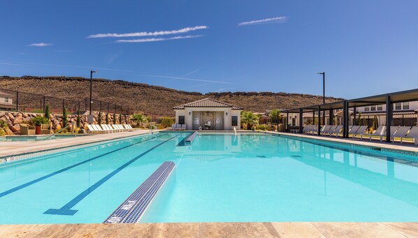 A swimming pool with lounge chairs and a building in the background. - Desert Oasis - Pool, Hot Tub and Pickleball Courts (Washington)