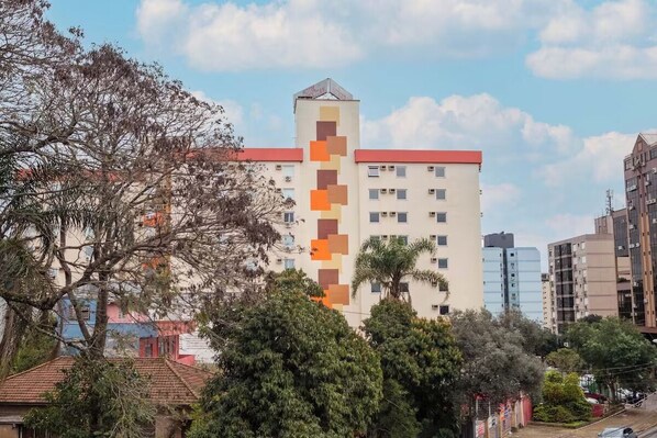 Un hotel de varios pisos con una fachada distintiva que presenta una serie de ventanas cuadradas y una torre central.