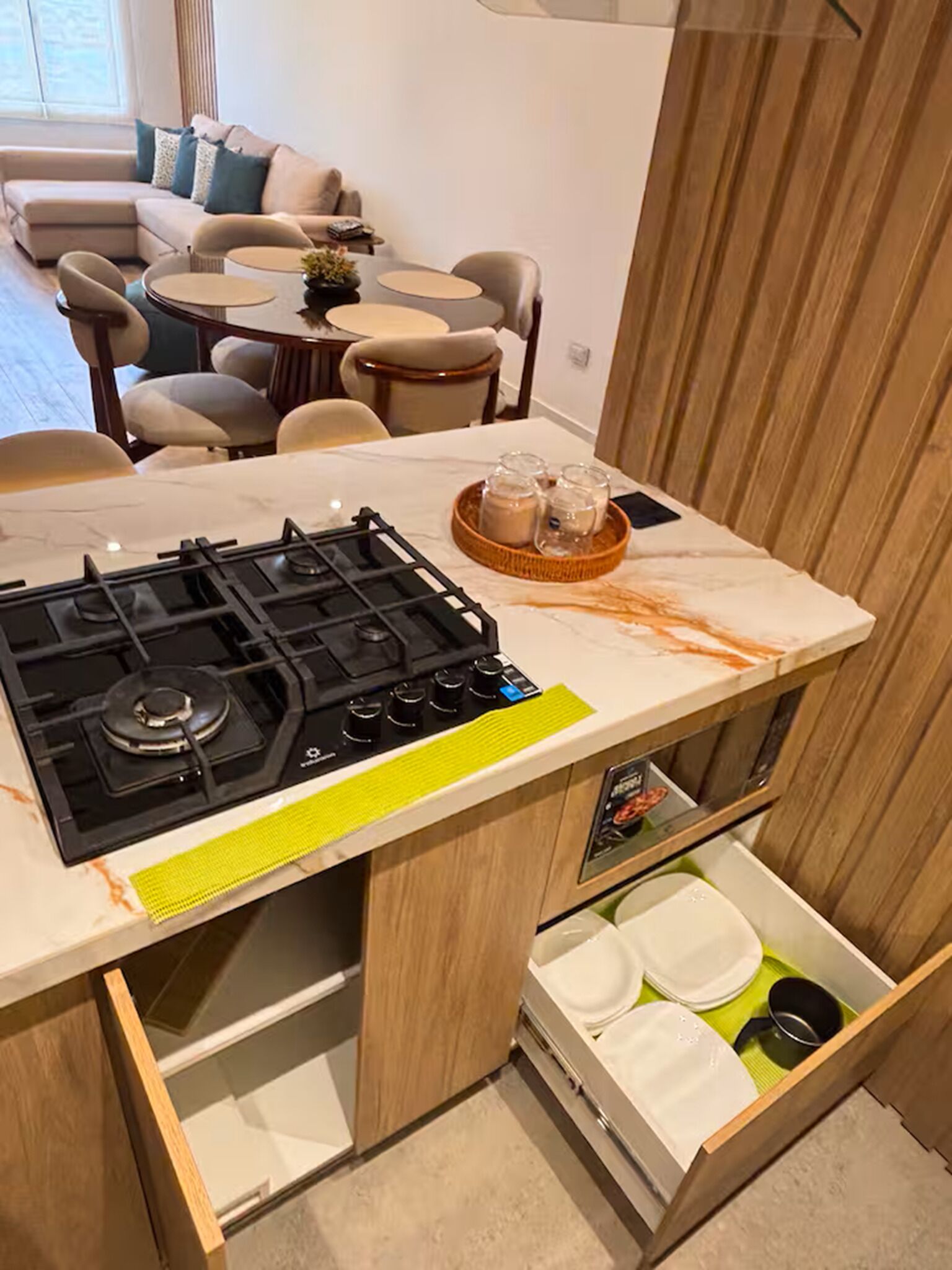 A compact kitchen with a gas stove, a sink, and a small dining area with chairs and a table.