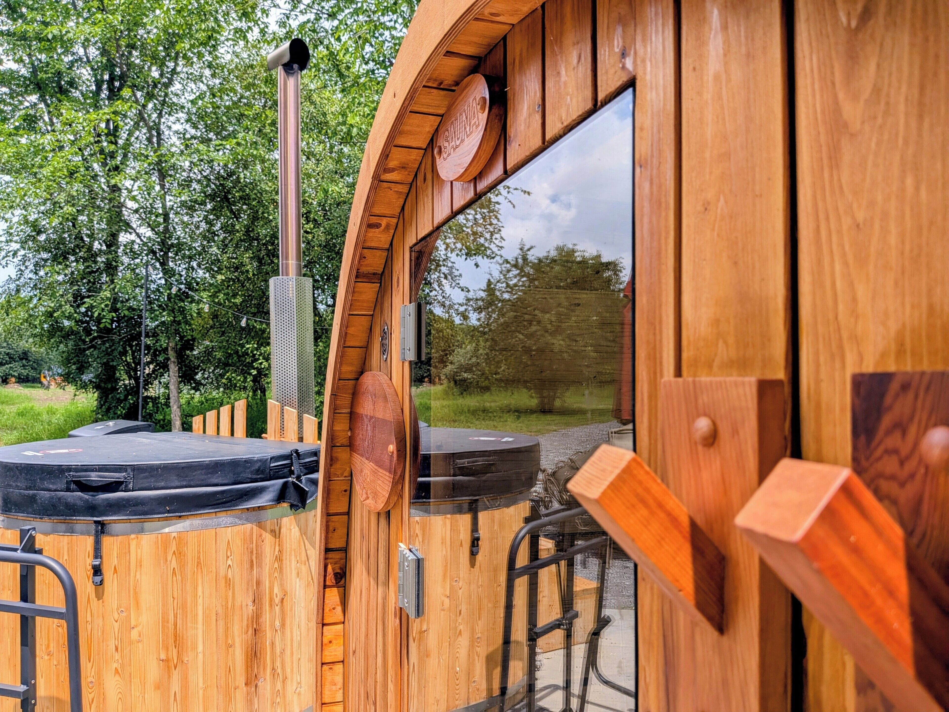 Eine Sauna mit Holzwänden, einem großen Fenster und einer Metalttür.