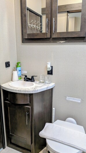 A bathroom with a sink, mirror, cabinet, and towel rack. - Furubekk • Nordic Spa RV • Pool • Sauna • Hot Tub • Ottawa (Mississippi Mills)