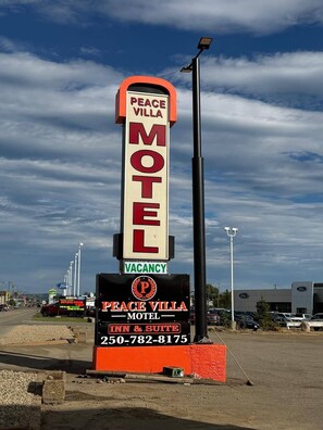 A motel sign with 'PEACE VILLA MOTEL' and a vacancy notice.