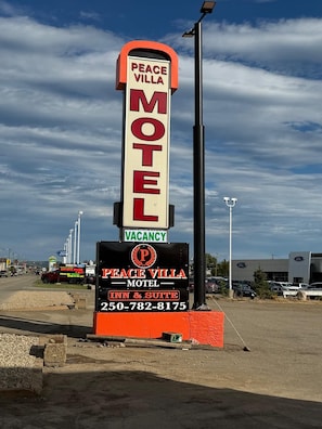 Letrero de motel con el nombre 'Peace Villa Motel' y aviso de habitaciones disponibles.