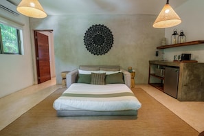 Une chambre à coucher avec un grand lit, des tables de chevet, un élément décoratif mural, une étagère intégrée et une fenêtre.