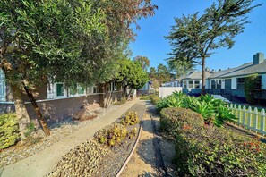 A residential street with houses, a gravel path, and various plants. - Cozy 2BR Long Beach Retreat (Long Beach)