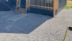 Un edificio moderno con una terraza de madera y una puerta de cristal.