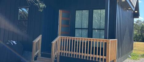 A modern building with a wooden deck and a glass door entrance.