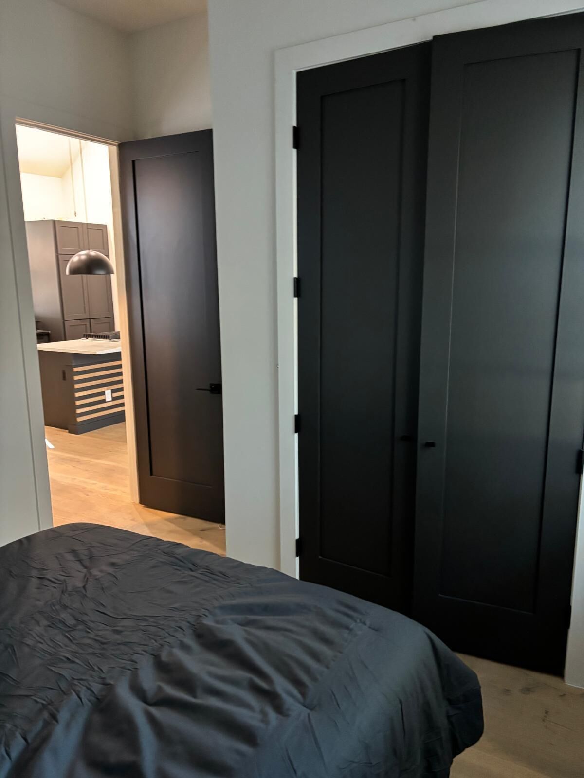 A bedroom with a bed, a wardrobe, and a door leading to a bathroom.