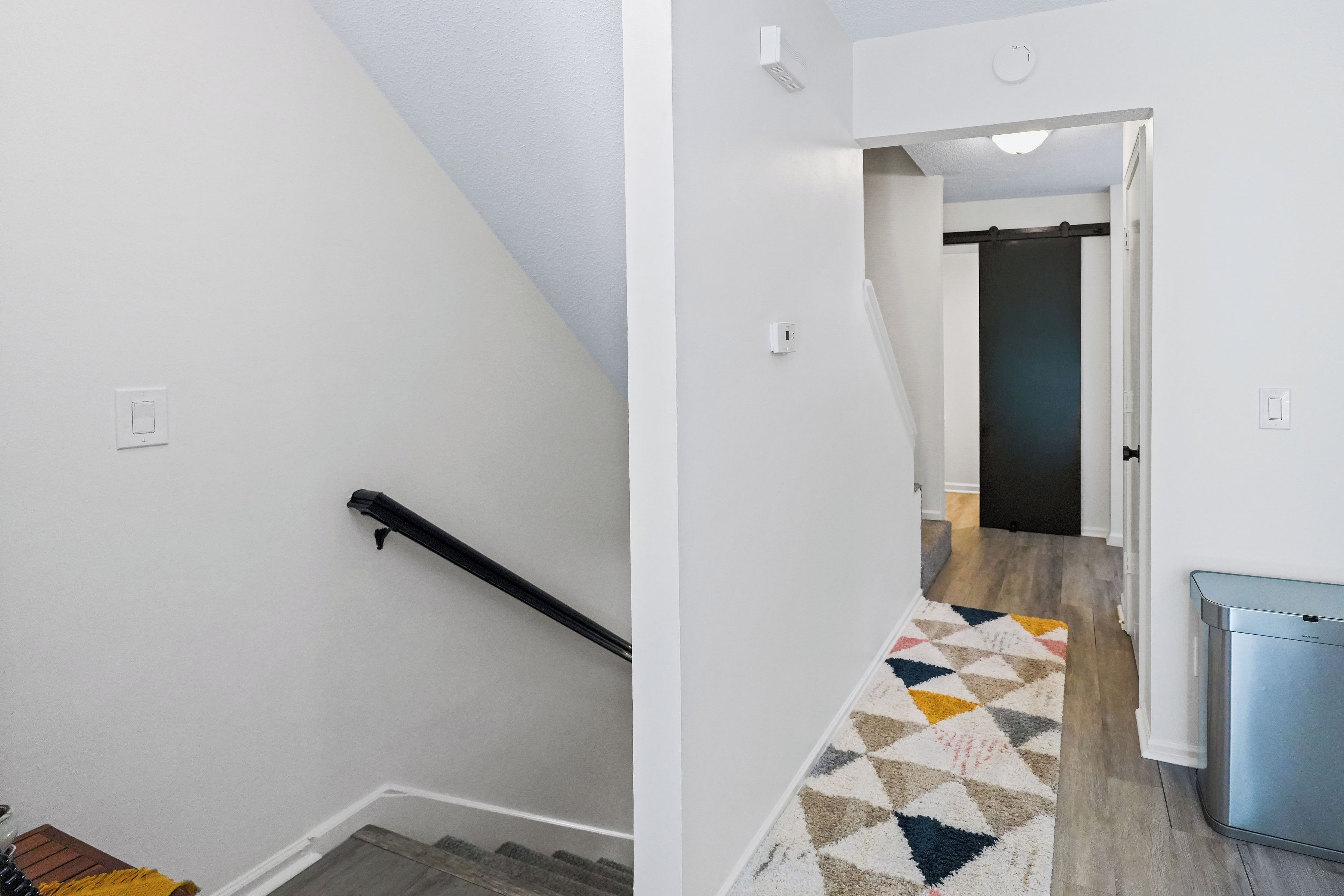 A staircase with a handrail and a carpeted landing.