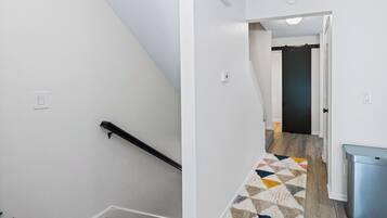 A staircase with a handrail and a carpeted landing.