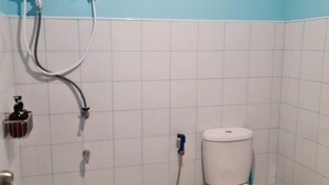 Un baño con inodoro blanco, ducha y lavamanos.