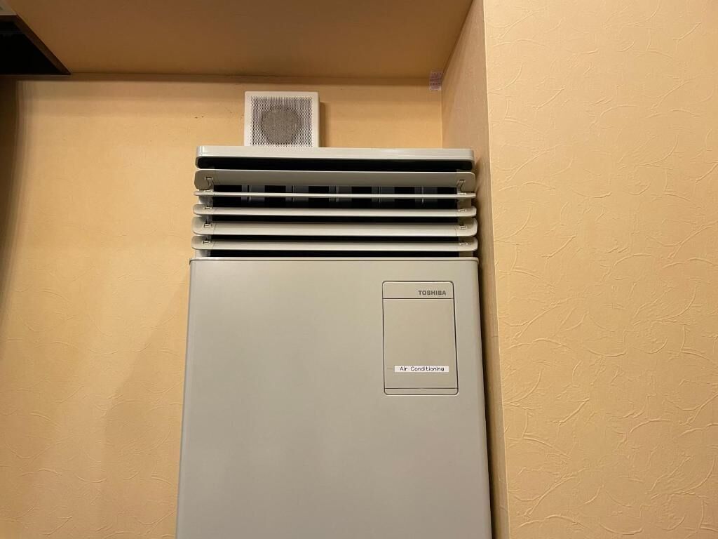 A Toshiba air conditioner unit in a room with beige walls.