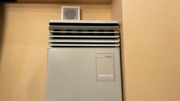A Toshiba air conditioner unit in a room with beige walls.