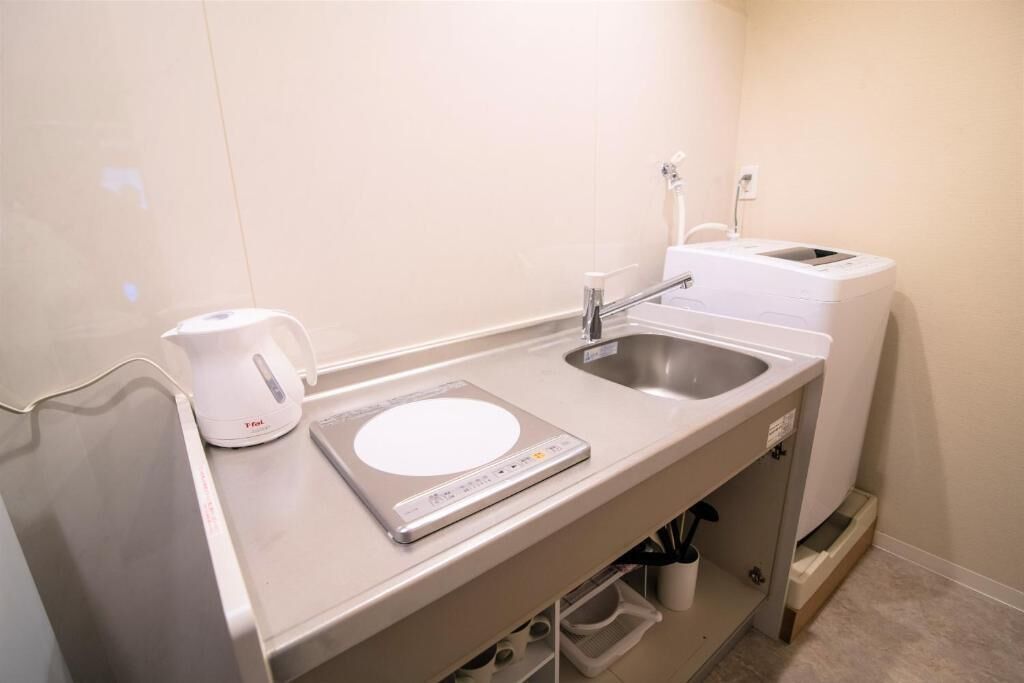 A kitchenette with a coffee maker, a scale, and a sink.