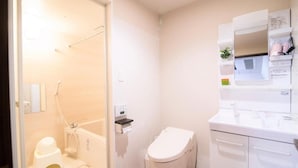 Een badkamer met een toilet, een douche en een wastafel.